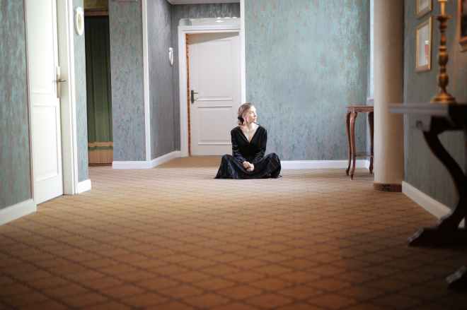woman wearing black dress sitting on the floor