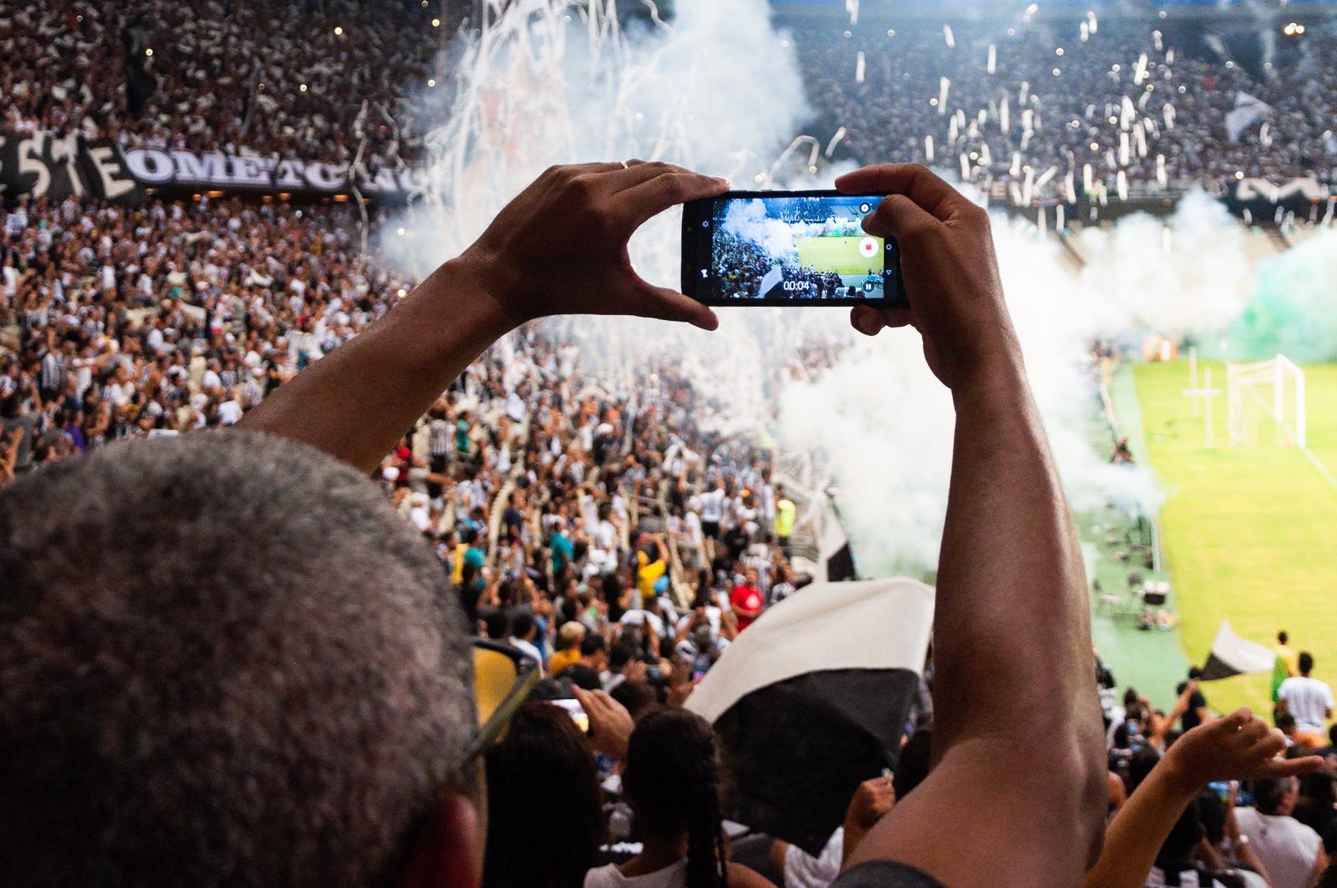 person taking photo of stage stadium presentation