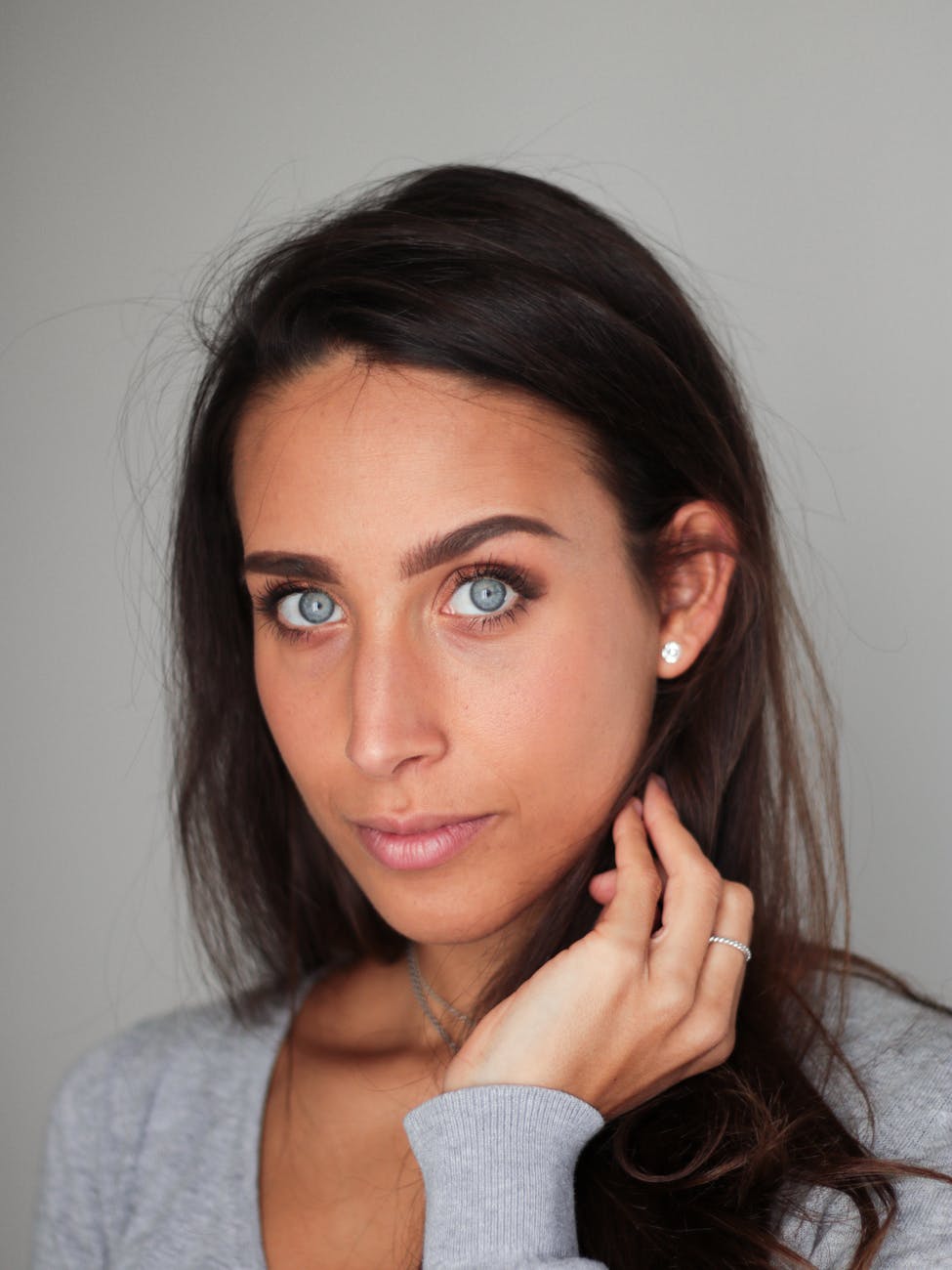 woman in gray sweater taking selfie