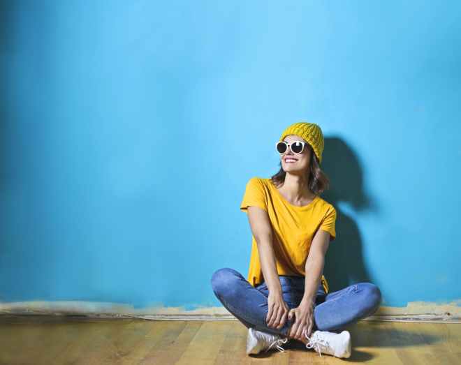 woman in yellow shirt sitting on brown wooden floor